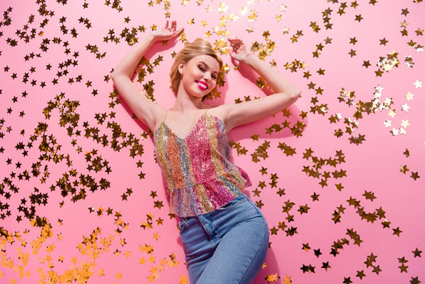 Photo of nice gorgeous cute woman lying floor elements golden sparkles stars occasion shiny sweet lady isolated on pink color background. - 写真・画像