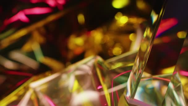 Αφηρημένο φόντο με γυάλινο πρίσμα που αντανακλά το φως σε χρυσά και κόκκινα λαμπερά σωματίδια - Πλάνα, βίντεο