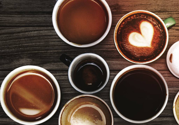 Асорті чашки кави на дерев'яному столі
 - Фото, зображення