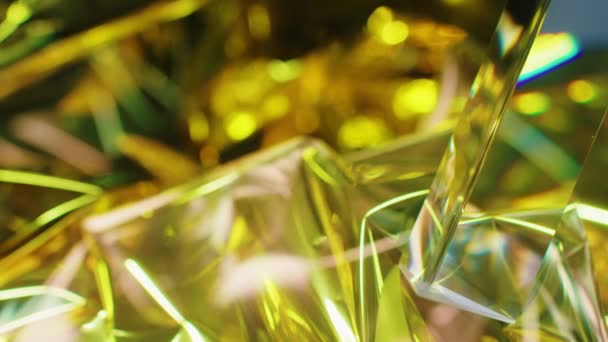 Abstrakcyjne tło z teksturą szklanego pryzmatu odbijającą złote światło - Materiał filmowy, wideo