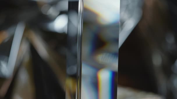 Επιλεκτική εστίαση κοντινό πλάνο του γυάλινου πρίσματος που κρέμεται και διασκορπίζει το φως σε μεταλλικό φόντο - Πλάνα, βίντεο