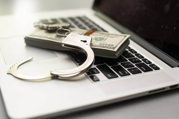 Handcuffs and dollars on keyboard, top view - Photo, Image