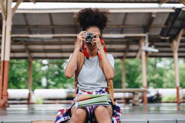 Asiatische Teenager-Mädchen afrikanisch-amerikanische Reisen mit einer Kamera ein Foto zu machen, um Erinnerungen zu erfassen, während sie auf einen Zug am Bahnhof warten - Foto, Bild
