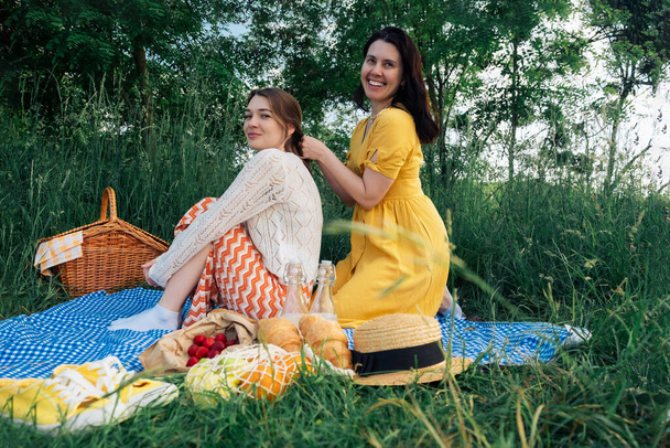 Dwóch przyjaciół na niebieskim kocu na piknik na świeżym powietrzu - Zdjęcie, obraz