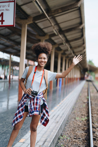 Afro-Amerikan turistler tren istasyonunda yolculuklarını beklerken mutlu yüz ifadeleri sergiliyorlar. - Fotoğraf, Görsel