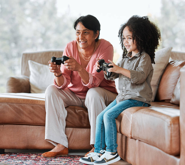 ソファ、コントローラー上のおばあちゃん、子供やビデオゲームは、ラウンジでの絆、コンテストや愛と一緒に幸せ。シニア女性,若い子供とゲームで遊んで,家族の家でのスポーツや競争. - 写真・画像