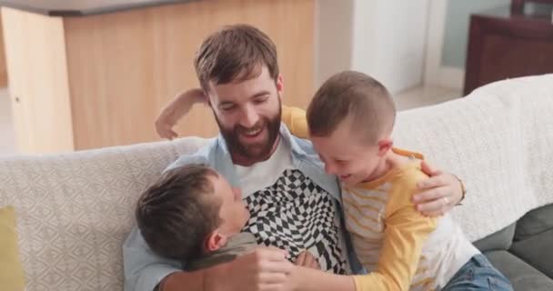 Happy, playful and relax with father and children on sofa for smile, hug and fun. Happiness, funny and care with man and kids in living room of family home for embrace and love together. - Footage, Video