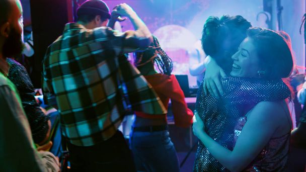 Ρομαντικά ζευγάρια που χορεύουν σε ζευγάρια στο πάρτι, ακούνε αργή μουσική στην πίστα και χορεύουν βαλς. Χορευτές που απολαμβάνουν βαλς στη ντισκοτέκ, διασκεδάζουν σε πάρτι στην κοινωνική συγκέντρωση. Χειροκίνητη βολή. - Φωτογραφία, εικόνα