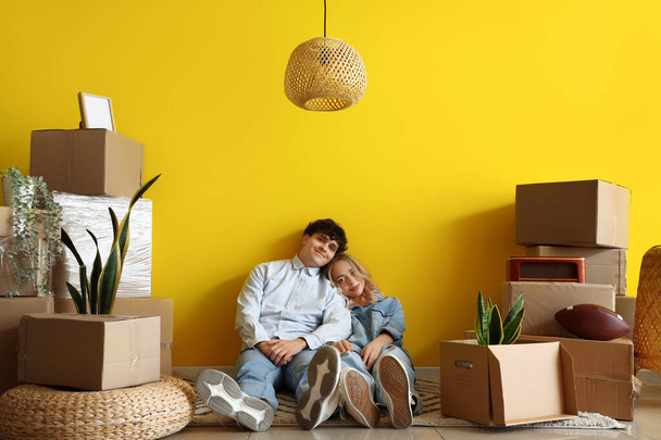 Happy young couple sitting in room on moving day - Photo, Image