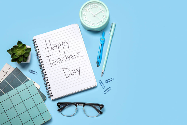 Zápisníky s textem HAPPY TEACHERS DAY, brýle a kancelářské potřeby na modrém pozadí - Fotografie, Obrázek