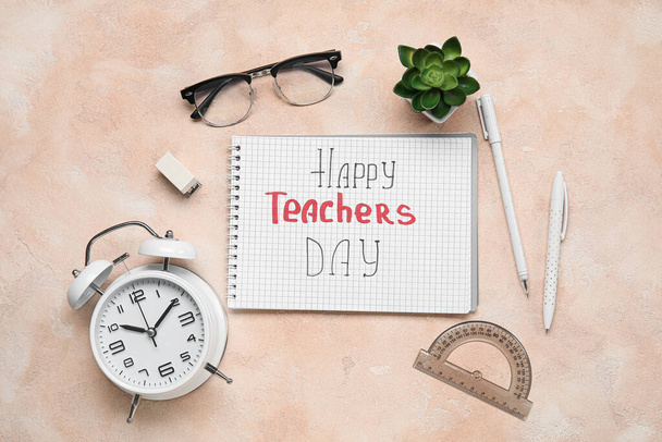 Notebook with text HAPPY TEACHERS DAY, eyeglasses and different stationery on grunge pink background - Foto, imagen