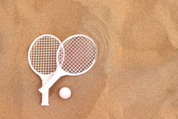 Beach tennis rackets and ball on sand, summer vacation activity - Fotoğraf, Görsel
