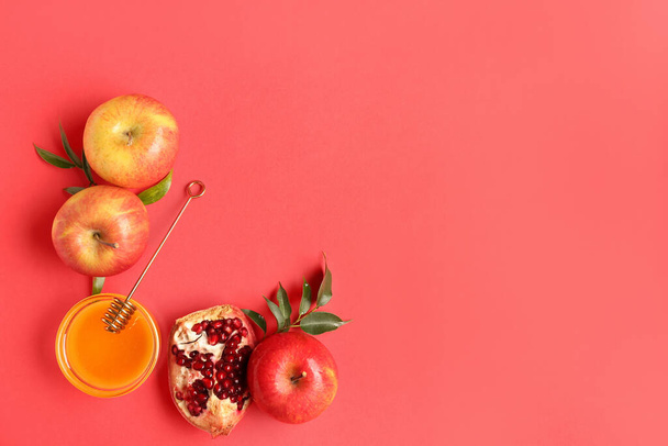 Jar medu, granátové jablko a jablka pro oslavu Rosh Hashanah (židovský Nový rok) na červeném pozadí - Fotografie, Obrázek