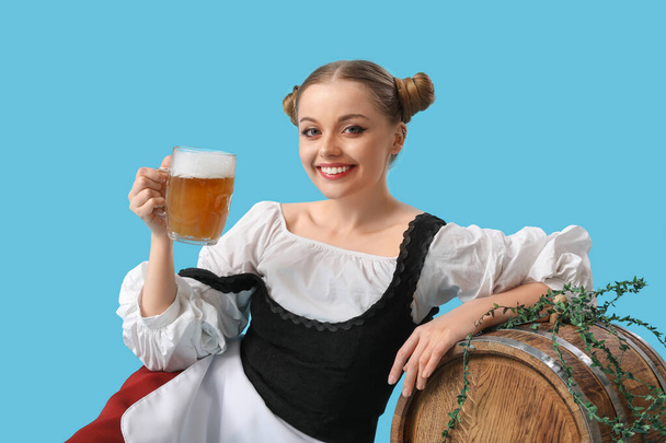 Gyönyörű Octoberfest pincérnő sör és hordó kék háttér - Fotó, kép