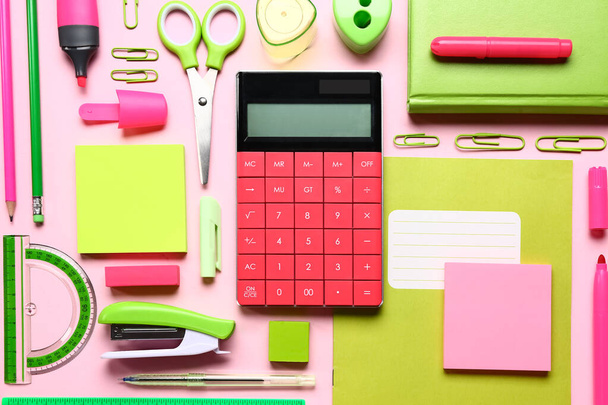 Calculatrice moderne avec papeterie différente sur fond rose - Photo, image