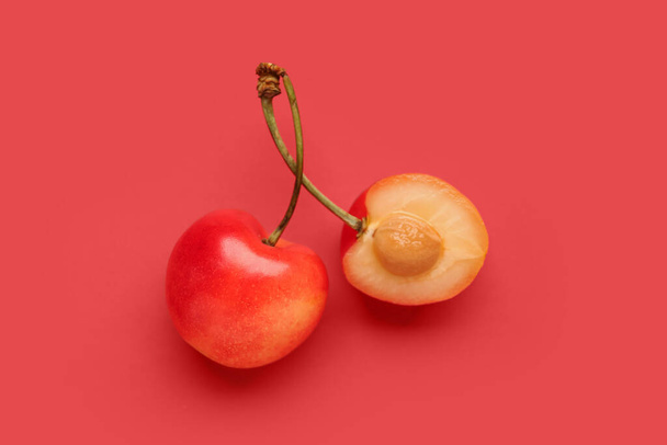 Sweet yellow cherry with half on red background - Photo, Image