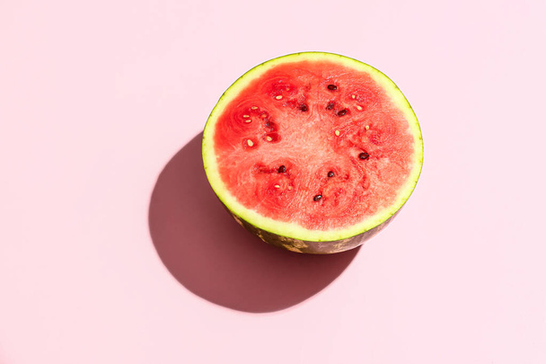 De helft van de zoetwatermeloen op roze achtergrond - Foto, afbeelding
