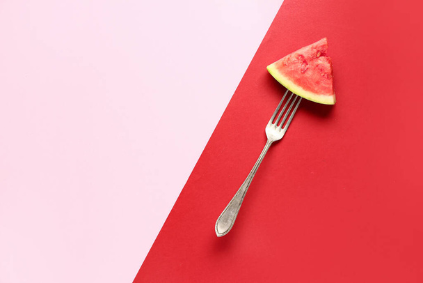 Fourchette avec morceau de pastèque fraîche sur fond coloré - Photo, image