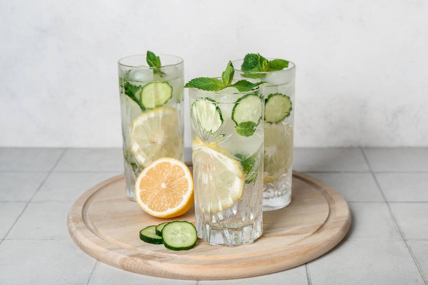 Glasses of mojito with cucumber on tile table - 写真・画像