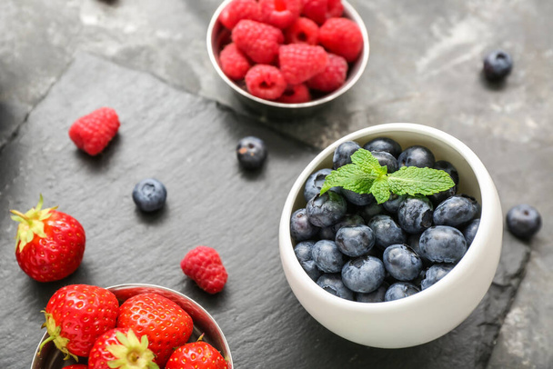 Bowls with different fresh berries on grey background, closeup - Photo, Image