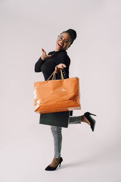 Shopping Concept - Portrait of young beautiful attractive African woman smiling and joyful with shopping bags. - Φωτογραφία, εικόνα