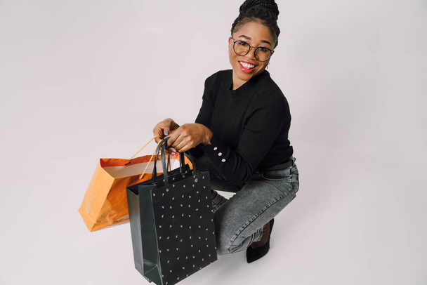 Shopping Concept - Portrait of young beautiful attractive African woman smiling and joyful with shopping bags. - Zdjęcie, obraz