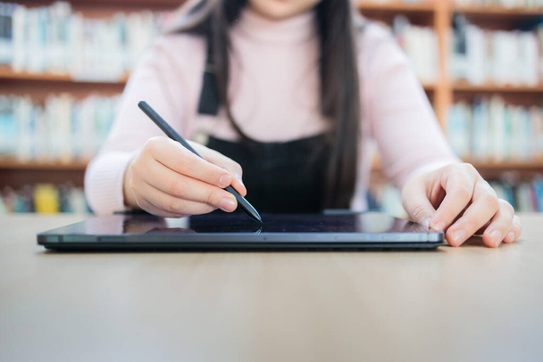 Academic Harrastukset: Nuori Nainen University Student Opiskelee hänen Tablet kirjastossa. Laadukas kuva - Valokuva, kuva