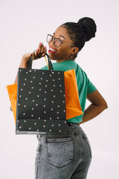 Shopping Concept - Portrait of young beautiful attractive African woman smiling and joyful with shopping bags. - Foto, immagini
