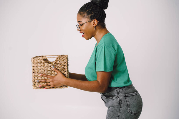 Beautiful African American woman standing holding basket. Happy Black girl in white background, Studio concept of wonderful black girl smiling on white background. - Photo, Image