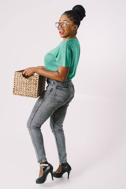 Beautiful African American woman standing holding basket. Happy Black girl in white background, Studio concept of wonderful black girl smiling on white background. - Fotoğraf, Görsel