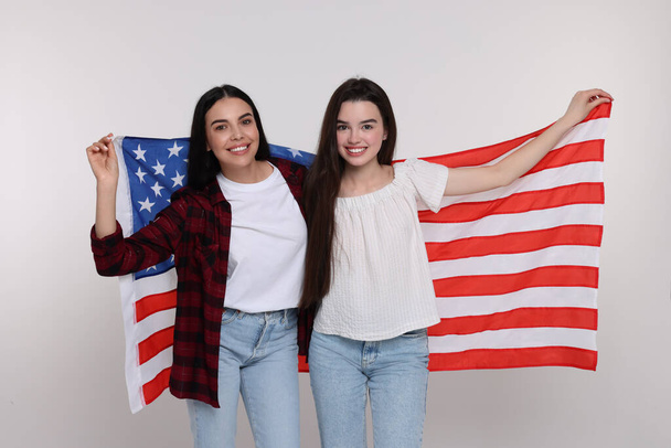 4th of July - Independence Day of USA. Happy woman and her daughter with American flag on white background - Valokuva, kuva