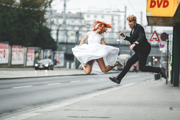 Wedding couple jumping in city - Fotoğraf, Görsel