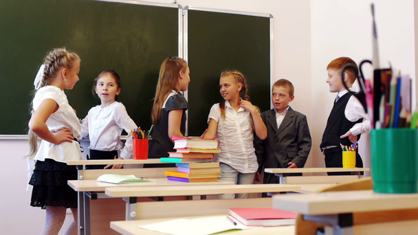 Dzieci w wieku szkolnym na czacie w pobliżu tablicy - Materiał filmowy, wideo