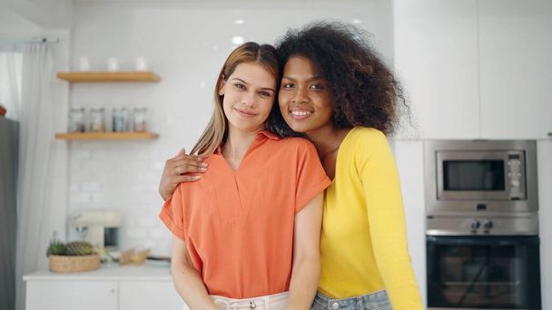 Close up multiracial lesbian women couple smiling to camera. Happy lesbian couple women embracing looking at camera. Lgbt relationship concept - Foto, Imagen