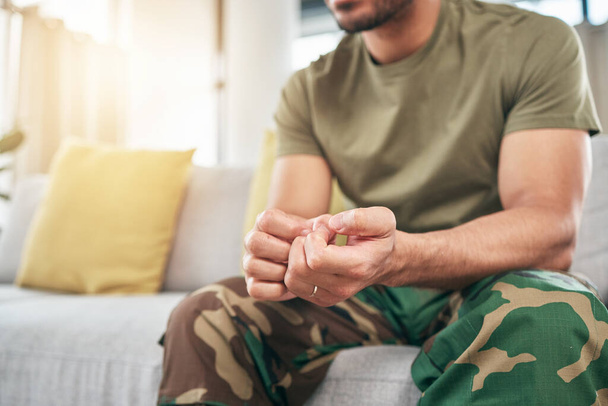 Hands, soldier on sofa and military man with anxiety, depression or problem in home living room. Army person, couch and ptsd, stress or crisis after war, trauma and waiting in lounge alone in house - Foto, Imagem