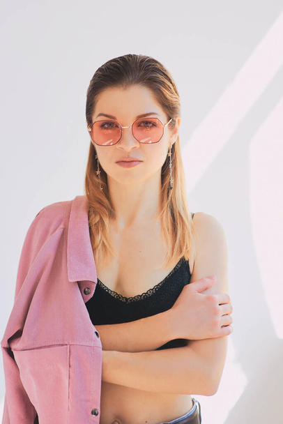 Portrait of young beautiful caucasian woman in dirty pink jacket and eye wear. Natural beauty, fashion, cosmetology - Foto, imagen