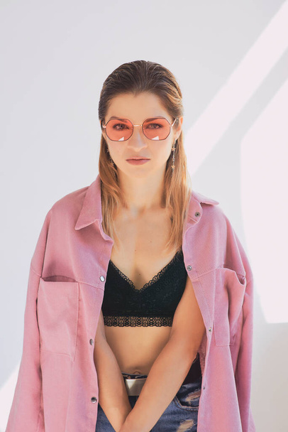 Portrait of young beautiful caucasian woman in dirty pink jacket and eye wear. Natural beauty, fashion, cosmetology - Фото, зображення