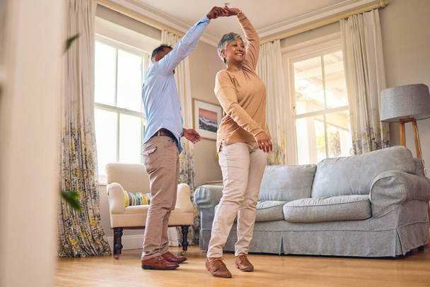 Retirement, romance and dance with a senior couple in the living room of their home together for bonding. Marriage, love or fun with an elderly man and woman dancing in the lounge of their house. - Foto, Imagen