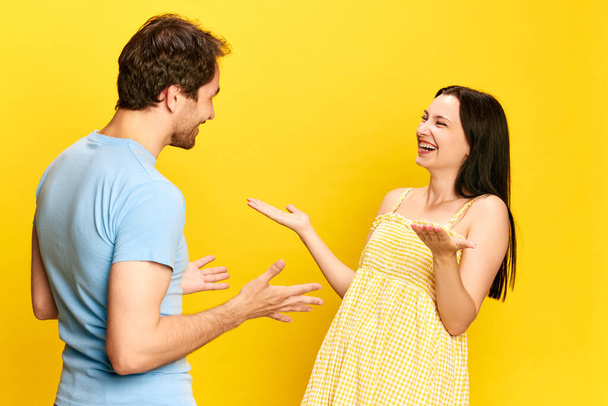 Big surprise and happiness. Young woman emotionally talking to her husband, expressing joy against yellow studio background. Concept of friendship, relationship, communication, emotions, lifestyle, ad - Foto, Bild