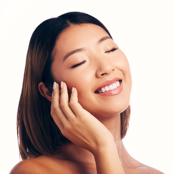Skincare, wellness and face of happy Asian woman on a white background for beauty, spa and cosmetics. Dermatology, salon and isolated female person with natural skin, satisfaction or facial in studio. - Foto, imagen