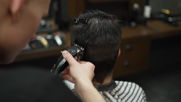 ヘアカットのためのクリッパーでメンズ髪を切断男のクローズアップ。ヘアカット用の美容クリップの助けを借りて髪の短縮 - 映像、動画