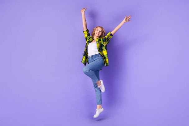 Full body photo of woman curly hair active weekend jump up high raised hands wear plaid stylish shirt isolated on violet color background. - Foto, Bild
