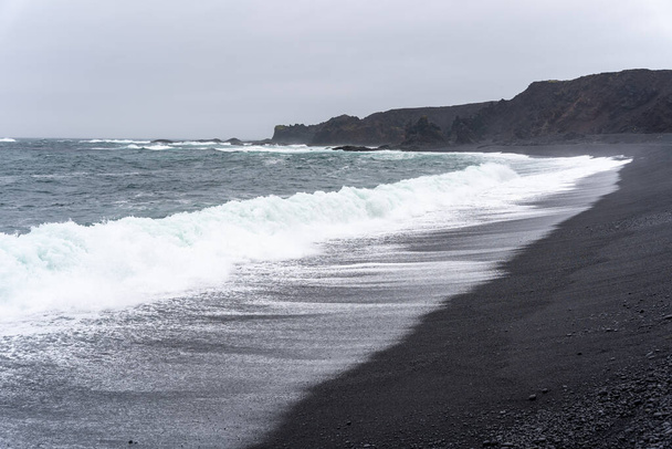 Vagues se lavant contre Djupalonssandur plage de sable noir en Islande - Photo, image