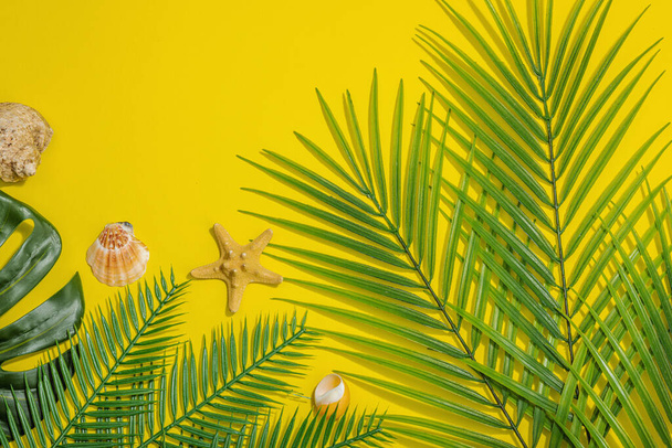 Concept vacances d'été. Décor marin, feuilles de palmier et de monstère. Fond jaune vif, lumière dure, ombre sombre, plan, vue sur le dessus - Photo, image