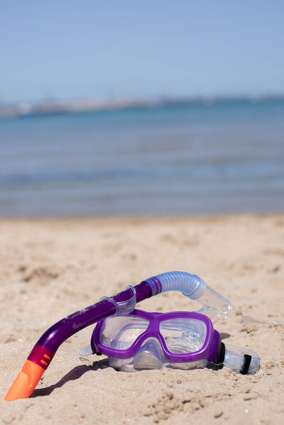 maska nurkowa dla dzieci na piasku na plaży w słoneczny dzień.Kopiuj space.Vertival zdjęcie. - Zdjęcie, obraz