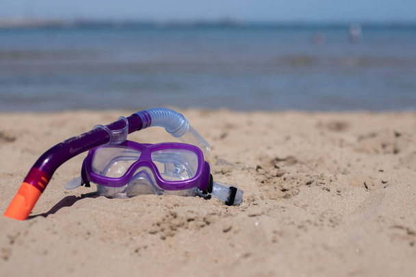 детский дайвинг маска на песке на пляже в солнечный день.. - Фото, изображение