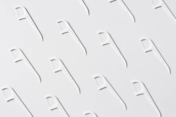 Vzor bílé zubní nitě s plastovým párátkem na bílém pozadí - Fotografie, Obrázek