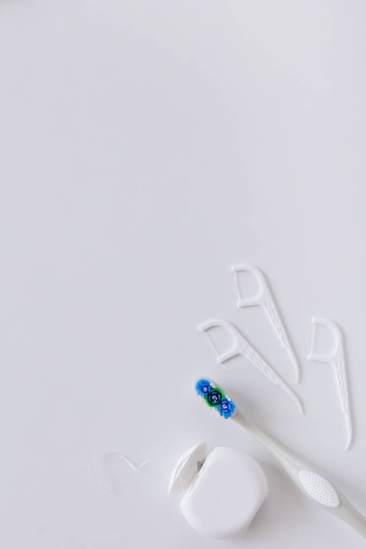 Λευκό οδοντικό νήμα, οδοντογλυφίδες και πινέλα σε λευκό φόντο με χώρο αντιγραφής - Φωτογραφία, εικόνα