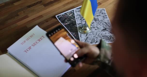 Vojenský špion zkoumá dokumenty o ukrajinské protiofenzívě a fotí smartphonem. Válka Ukrajiny a Ruska - Záběry, video