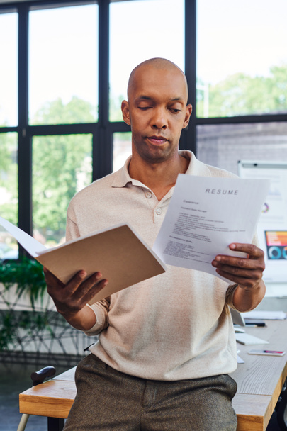 темношкірий чоловік із хворобою міастенії, що тримає резюме та папку, сміливий афроамериканський офісний працівник з синдромом Птозіса, включенням, графікою на фоні  - Фото, зображення